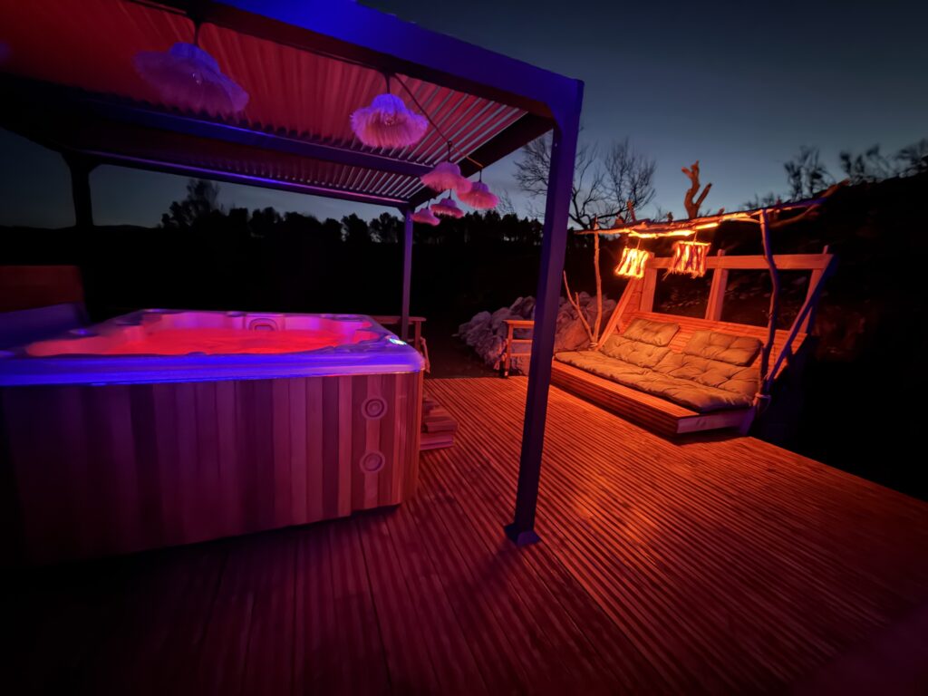 Terrasse avec spa privatif illuminé de nuit pour un week-end en amoureux dans l'Aude.