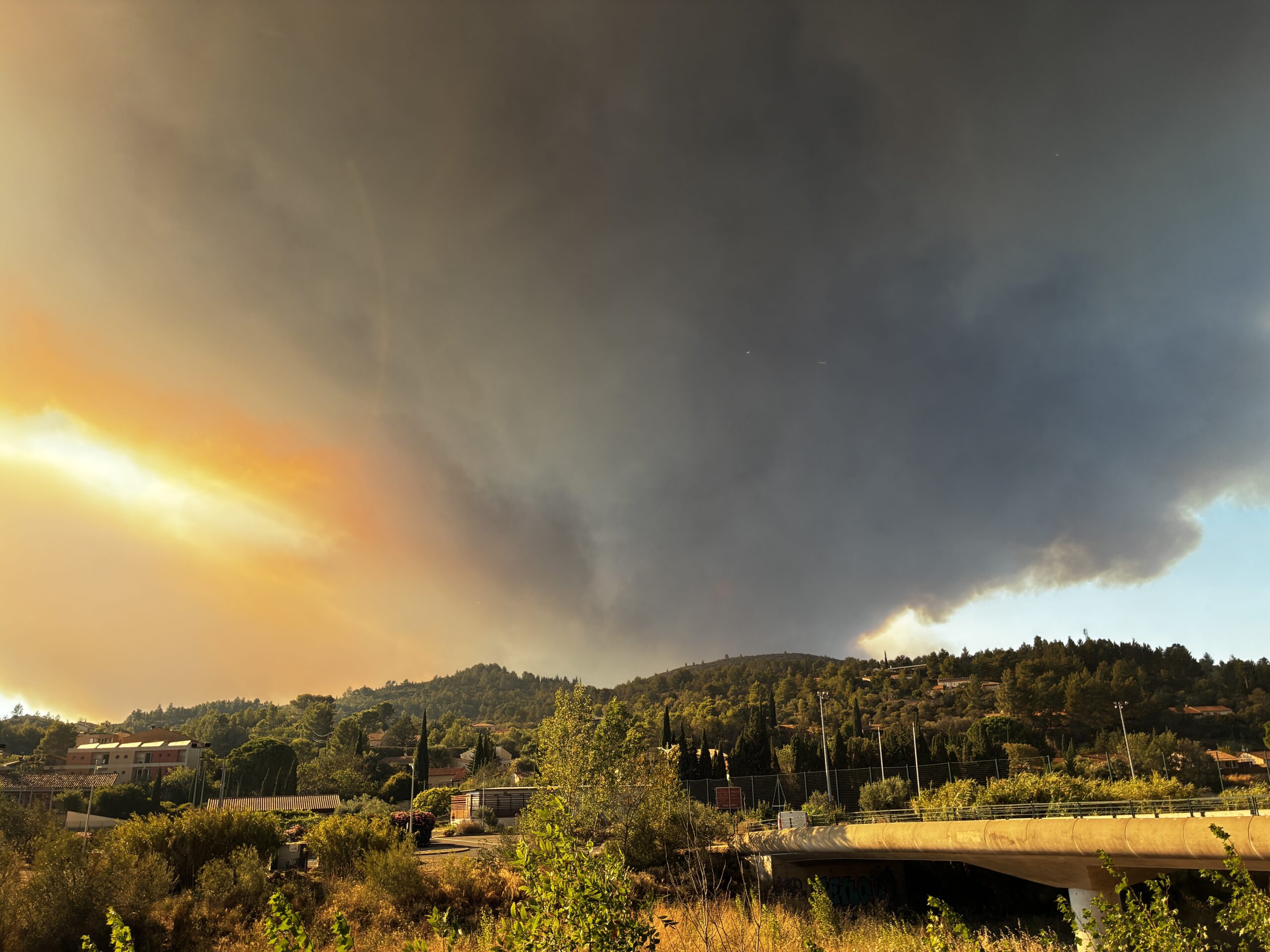 Vue du domaine vers Ribaute avec une épaisse fumée se dirigeant vers le Secret des Cigales, moment intense au cœur de l'Aude sauvage.