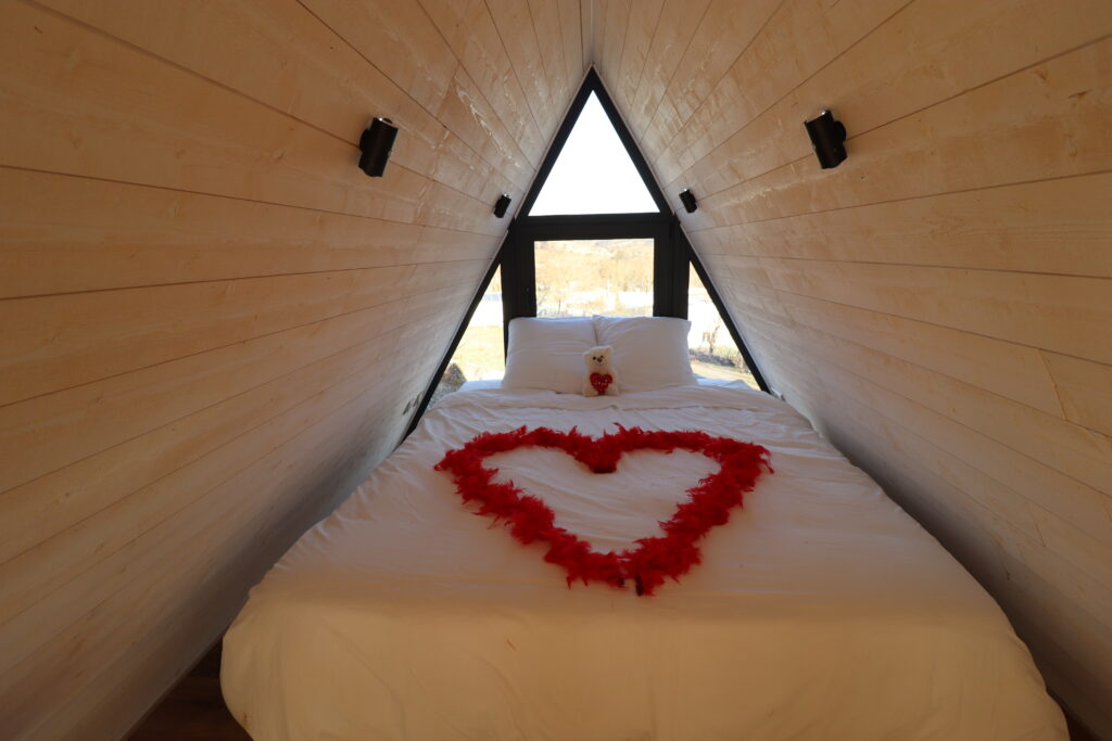 Lit double avec décoration romantique en forme de coeur dans la cabane L'Amoré