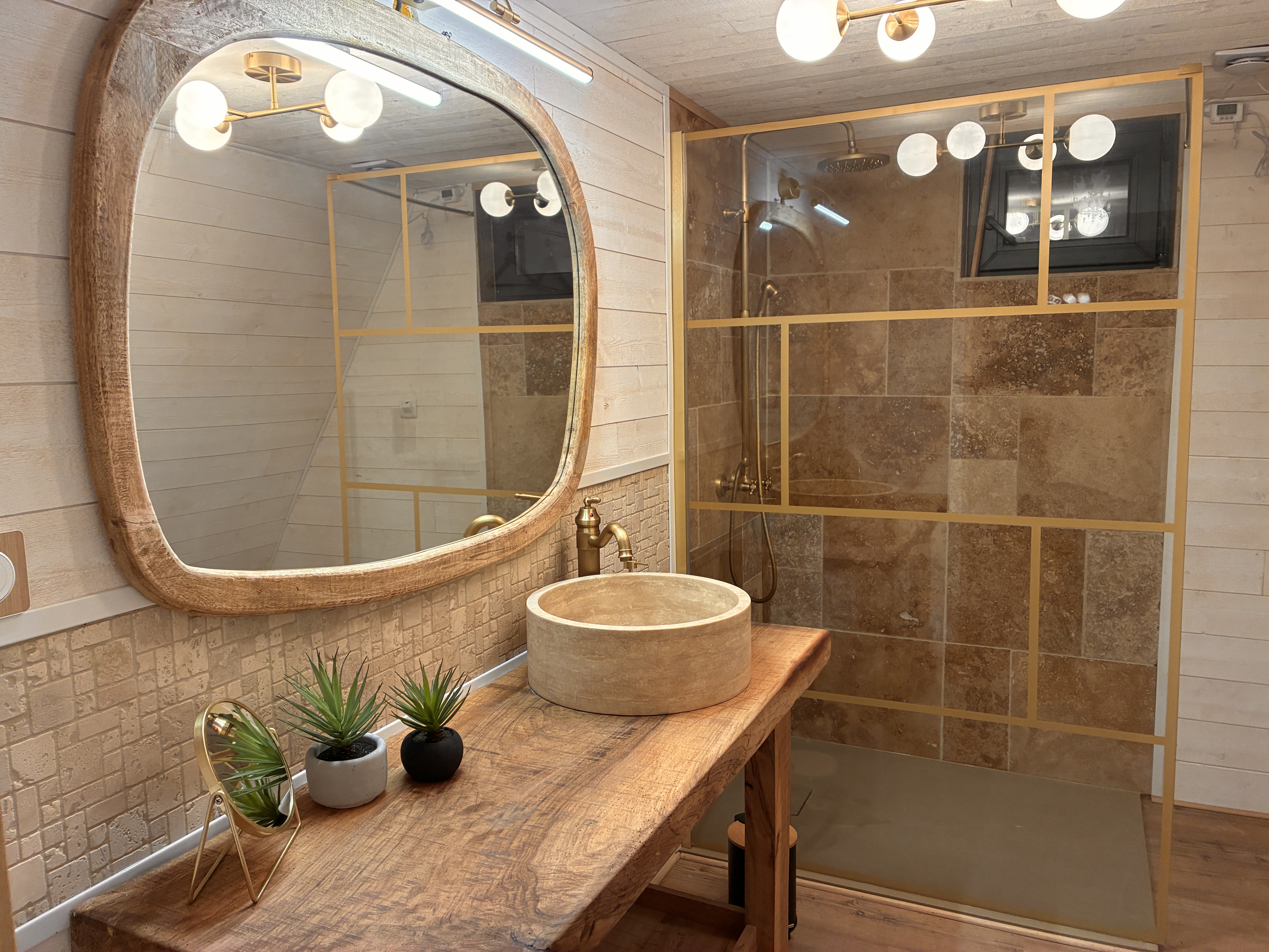 Salle de bain moderne et authentique avec vasque en pierre du Secret des Cigales.